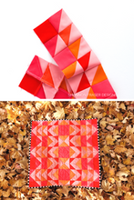 Load image into Gallery viewer, The Ode to Coral Modern Aztec quilt bursts with energy! Designed with 10 fabrics in coral, pink, and orange, this quilt uses strategic color placement for a vibrant ombré effect that adds depth and drama. A great choice for summer quilting or bold home décor.