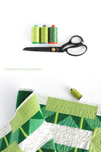 Load image into Gallery viewer, Green ombre large Aurifil thread spools with black tailor's shears and the Green ombre  Shattered Star quilted table runner | modern quilt pattern by Shannon Fraser Designs #quilting