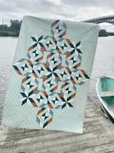 Load image into Gallery viewer, Quilt with geometric pattern on a wooden dock by a body of water