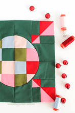 Load image into Gallery viewer, Quilt block with geometric pattern on a white background, featuring fabric rolls and small Christmas ornaments.