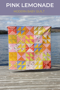 Pink Lemonade modern baby quilt shown in Aerial paired with Ruby and Bee solids for a fun girly baby quilt #babyquilt #modernquilt #quilting