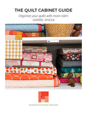 Load image into Gallery viewer, Book cover of 'The Quilt Cabinet Guide' by Shannon Fraser Designs with colorful quilts on a shelf.